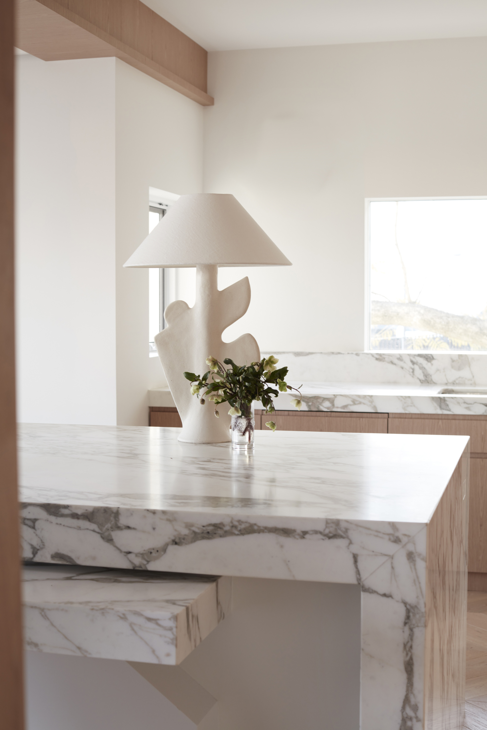 Calacatta Vagli marble kitchen island with waterfall edge and timber cabinets
