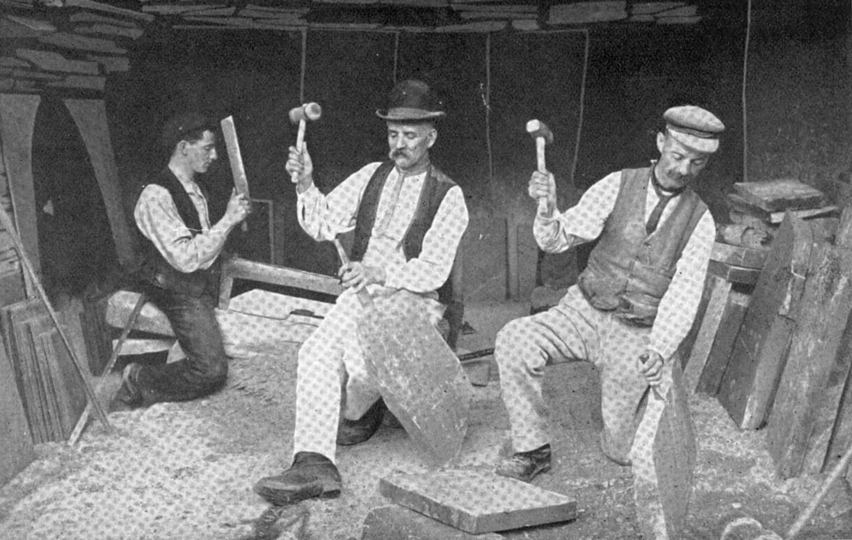 Three quarrymen splitting slate by hand at Dinorwig Quarry, Wales, around 1910